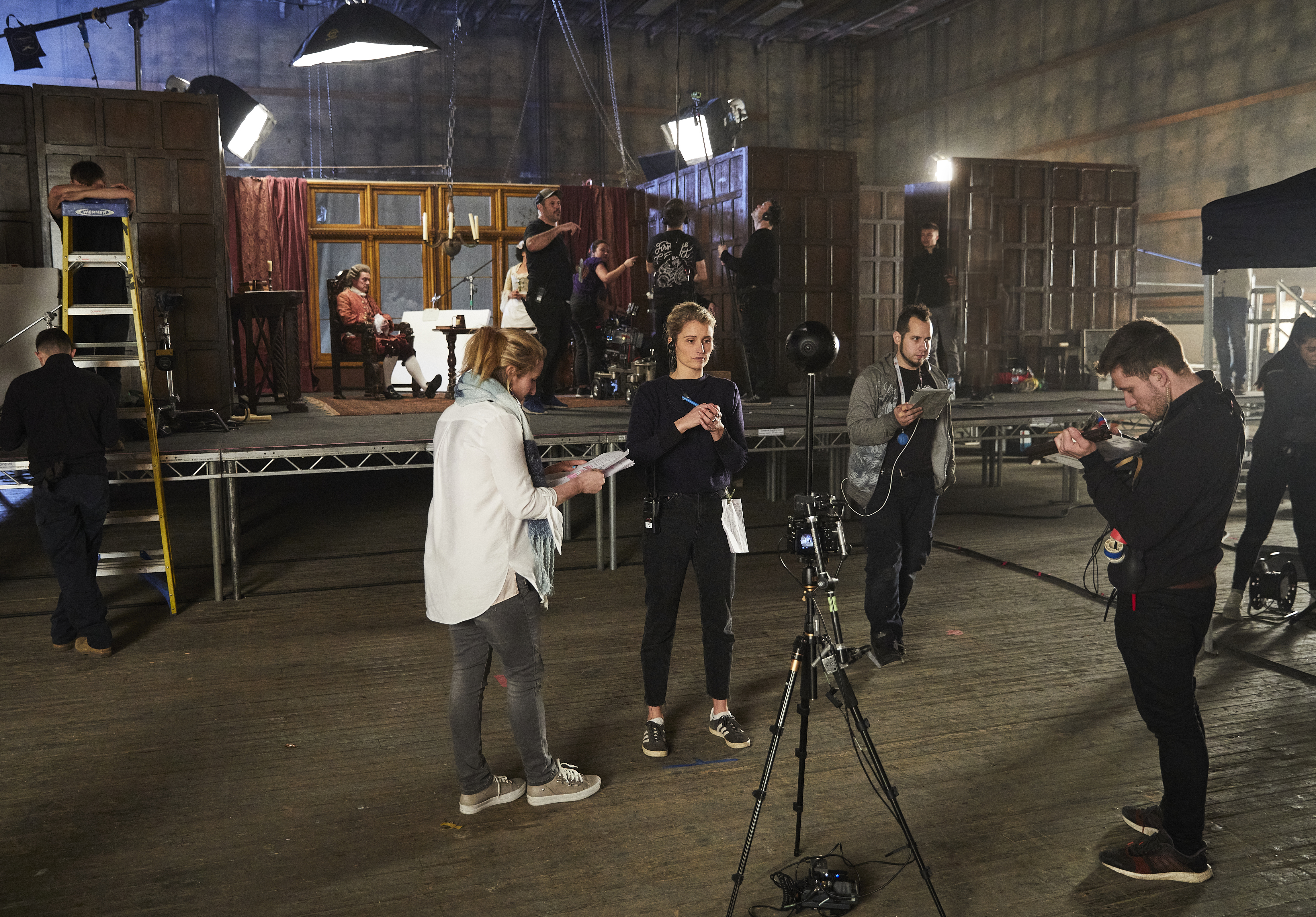 Four people stand around a 360 camera rig on set