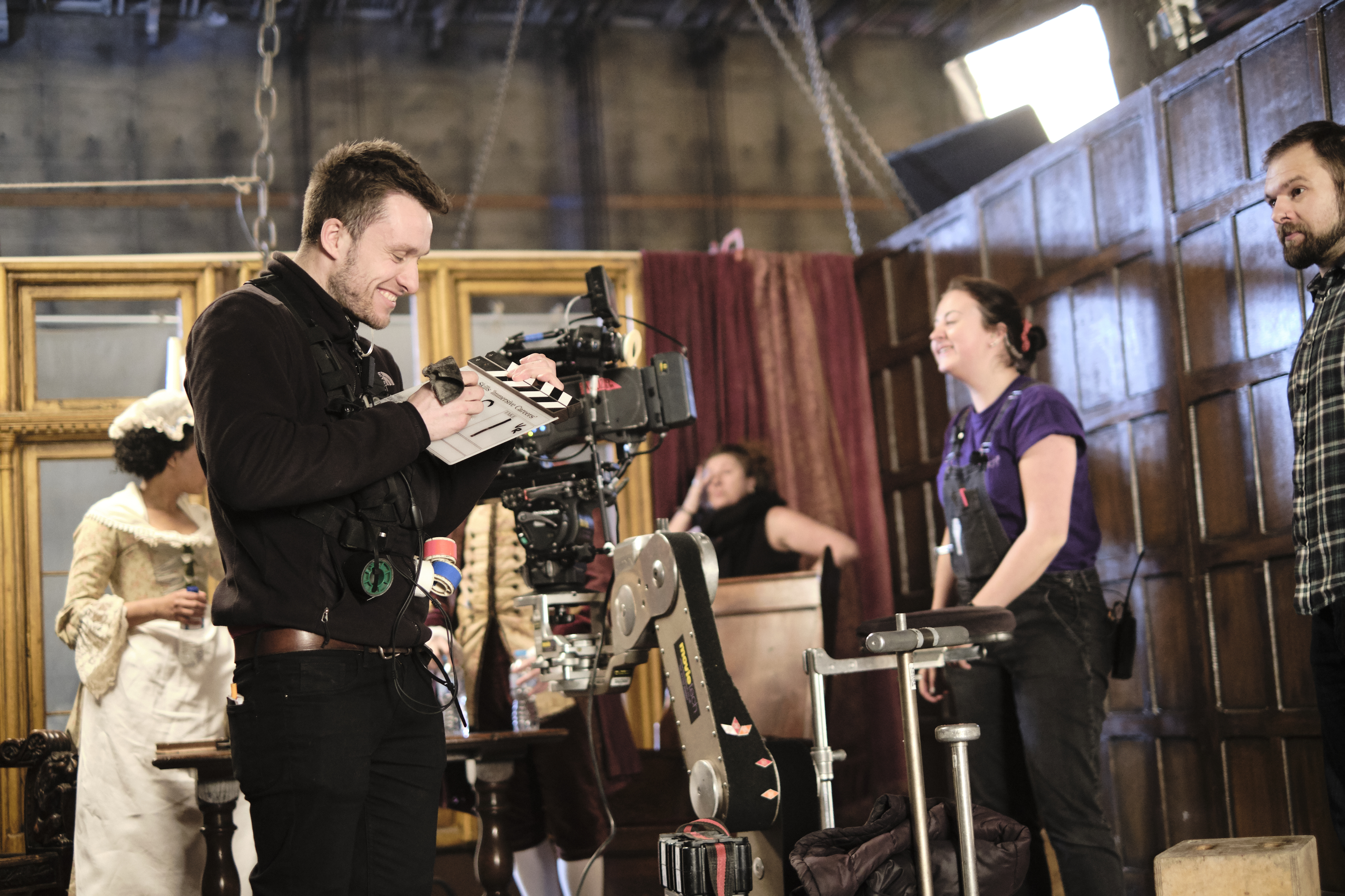 Behind the scenes image of cameraman and other crew on set of a period drama