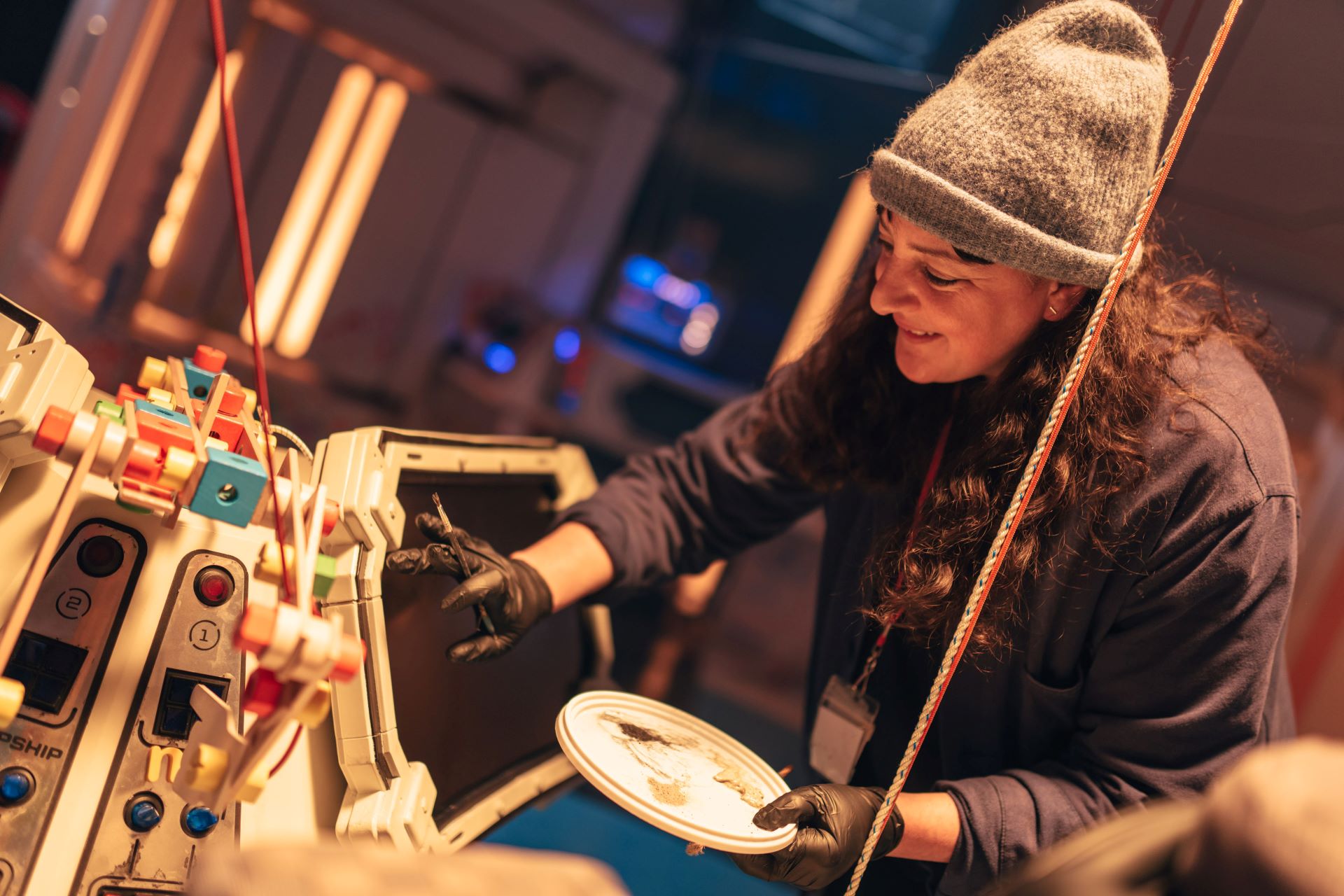 Woman wearing gloves painting part of the set on the set of Doctor Who