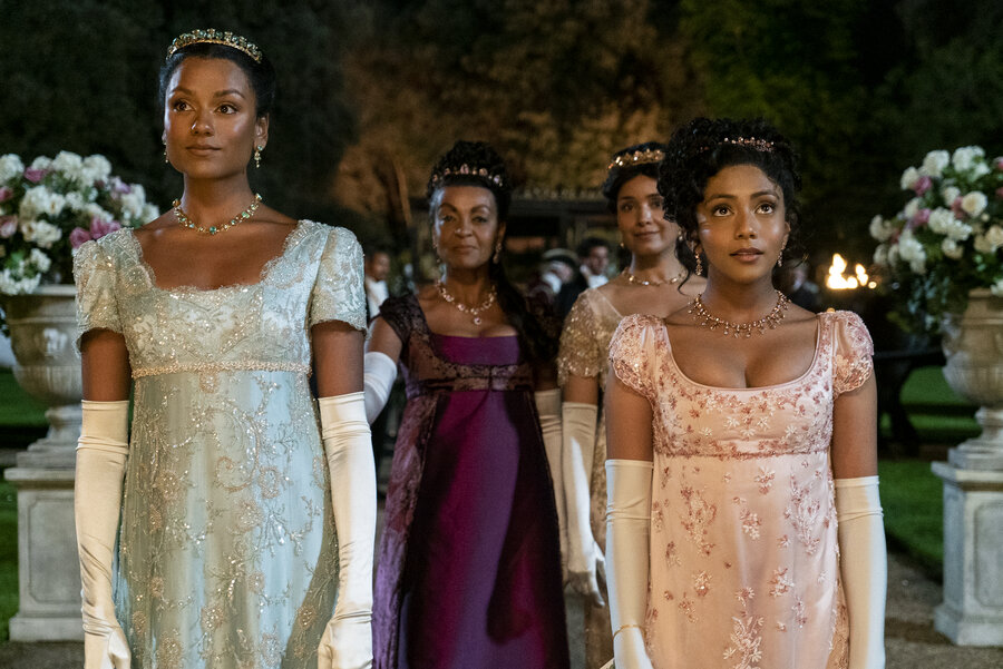 Image of actors Simone Ashley, Adjoa Andoh, Charithra Chandran and Shelley Conn wearing brightly coloured period dress walking through a garden of flowers in Bridgerton