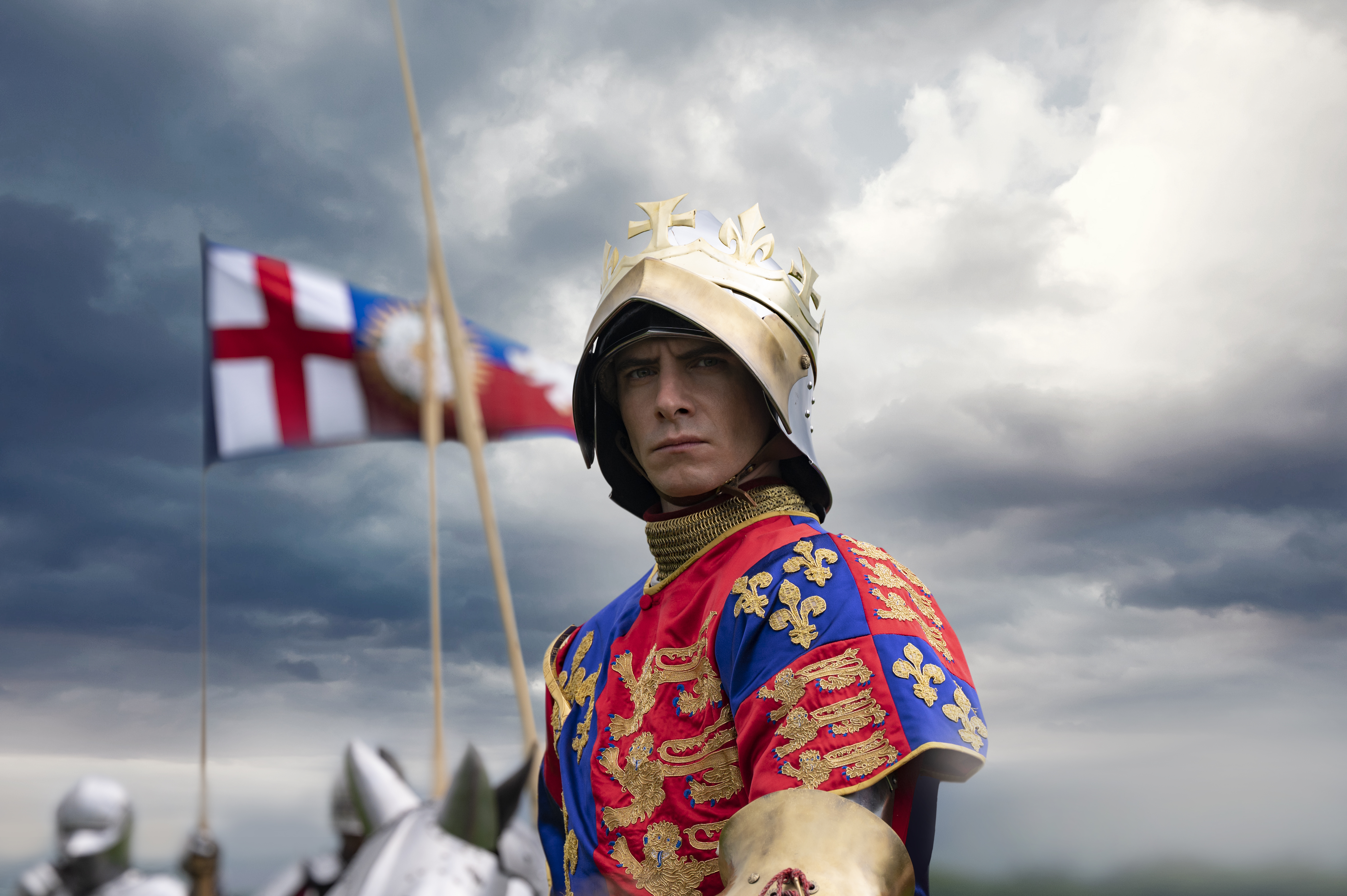 Actor dressed as a king on a horse with flag in background
