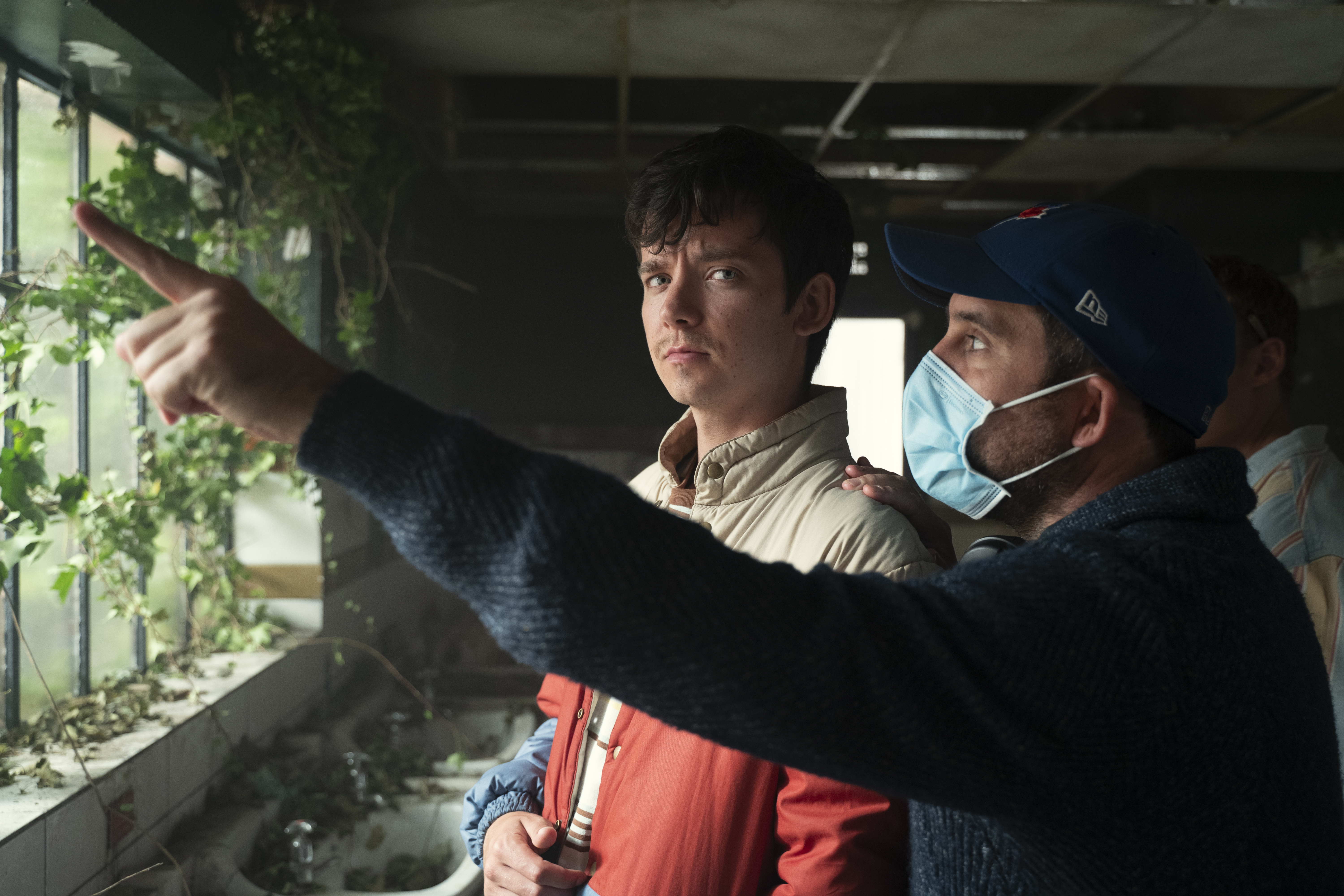 A member of crew gives instruction to Sex education actor.