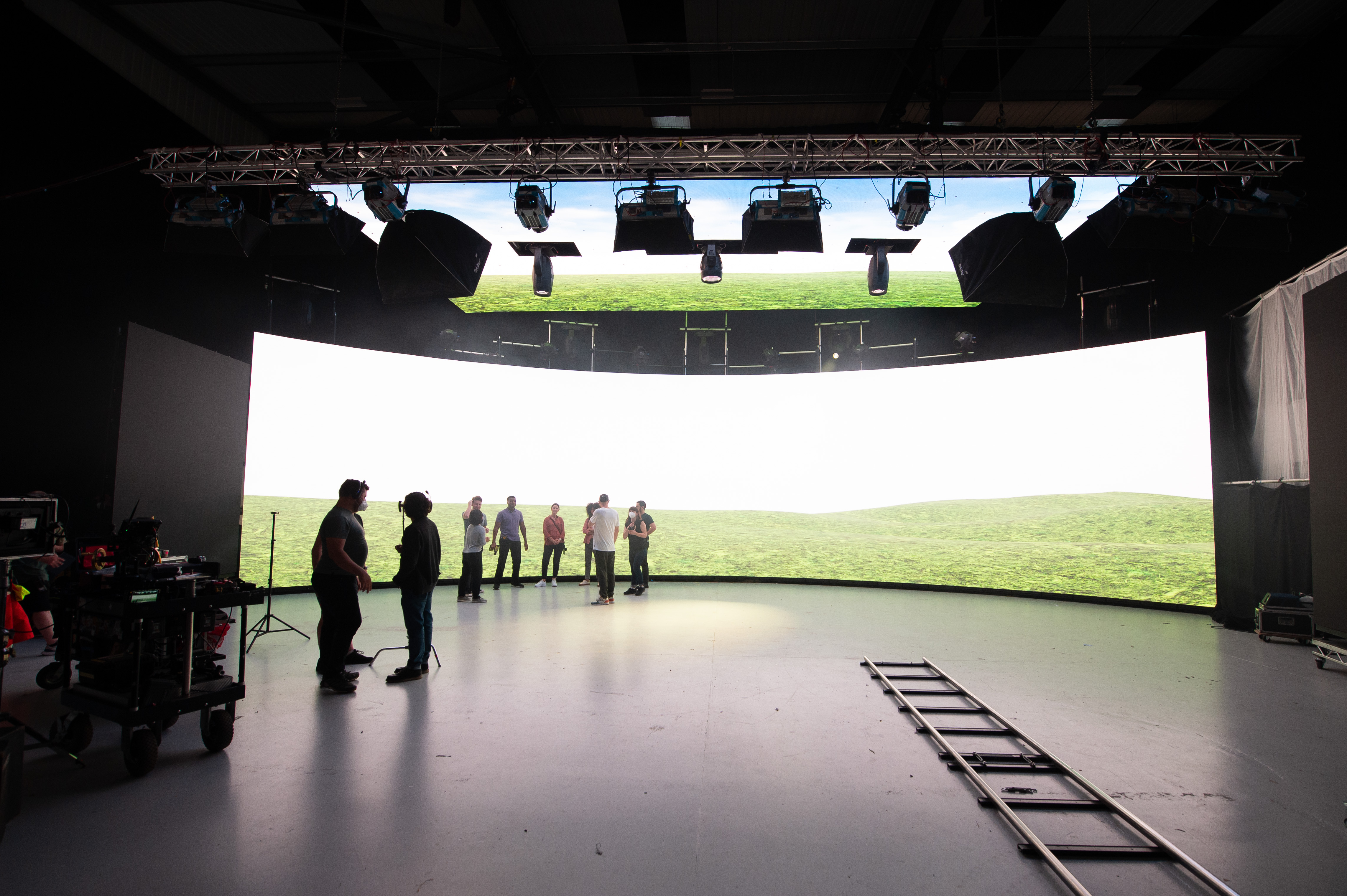 Crew in front of a virtual production screen showing a hill