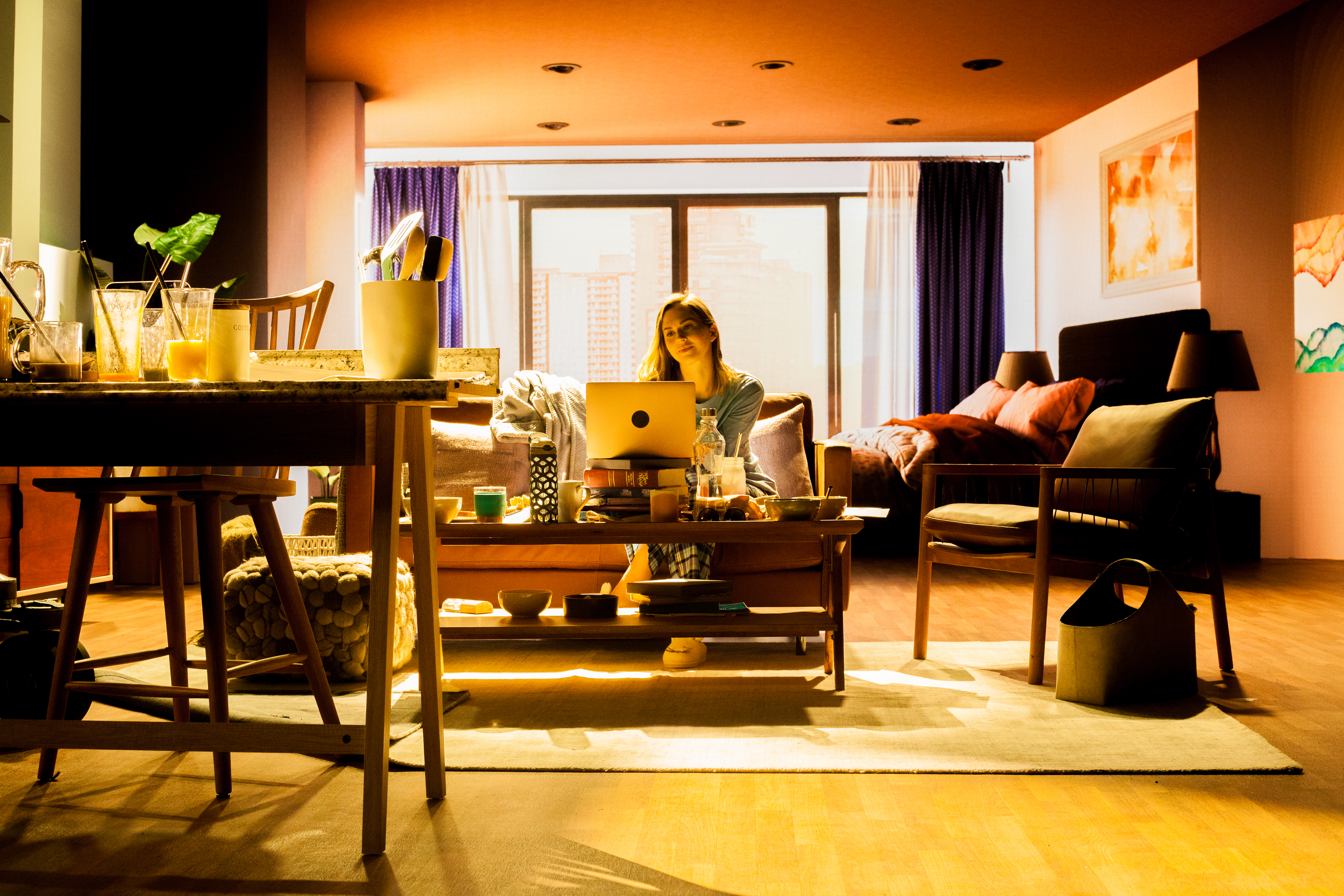 Actor in a virtual production set with a screen in the background showing the inside of a room