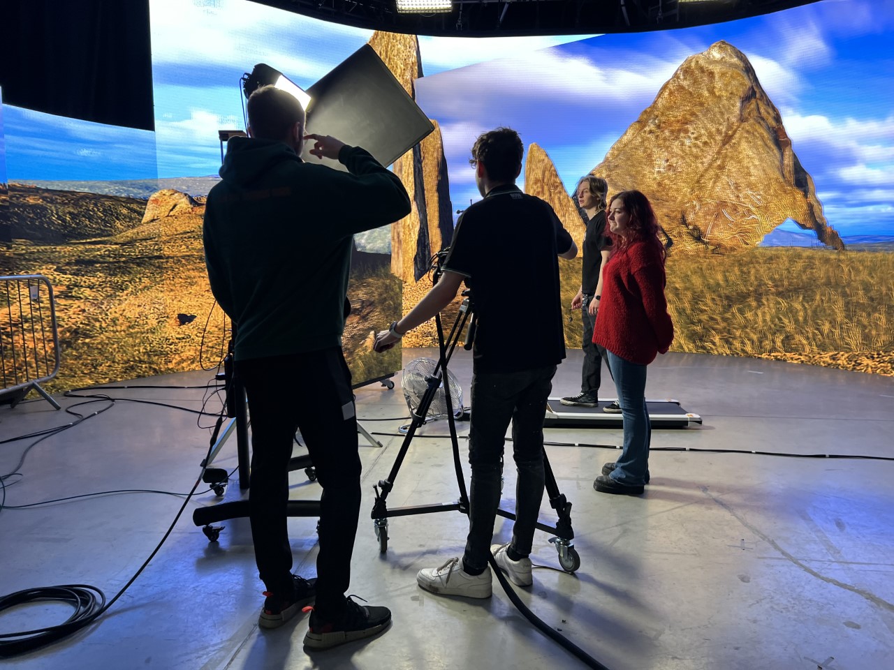 Four people working on a virtual production set with lighting