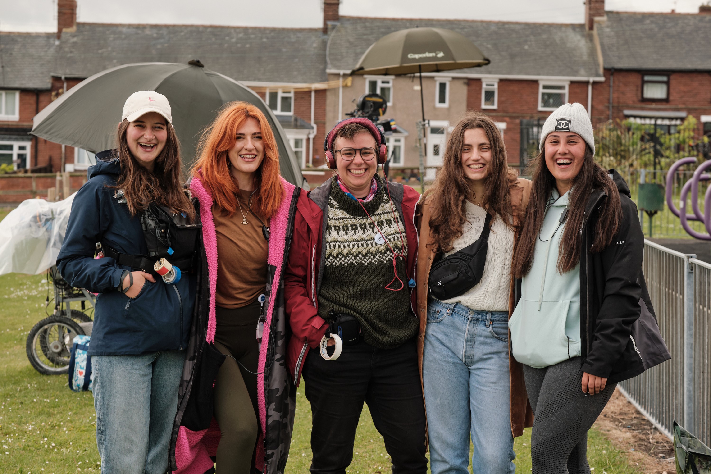 Five trainees are standing in a group close together smiling