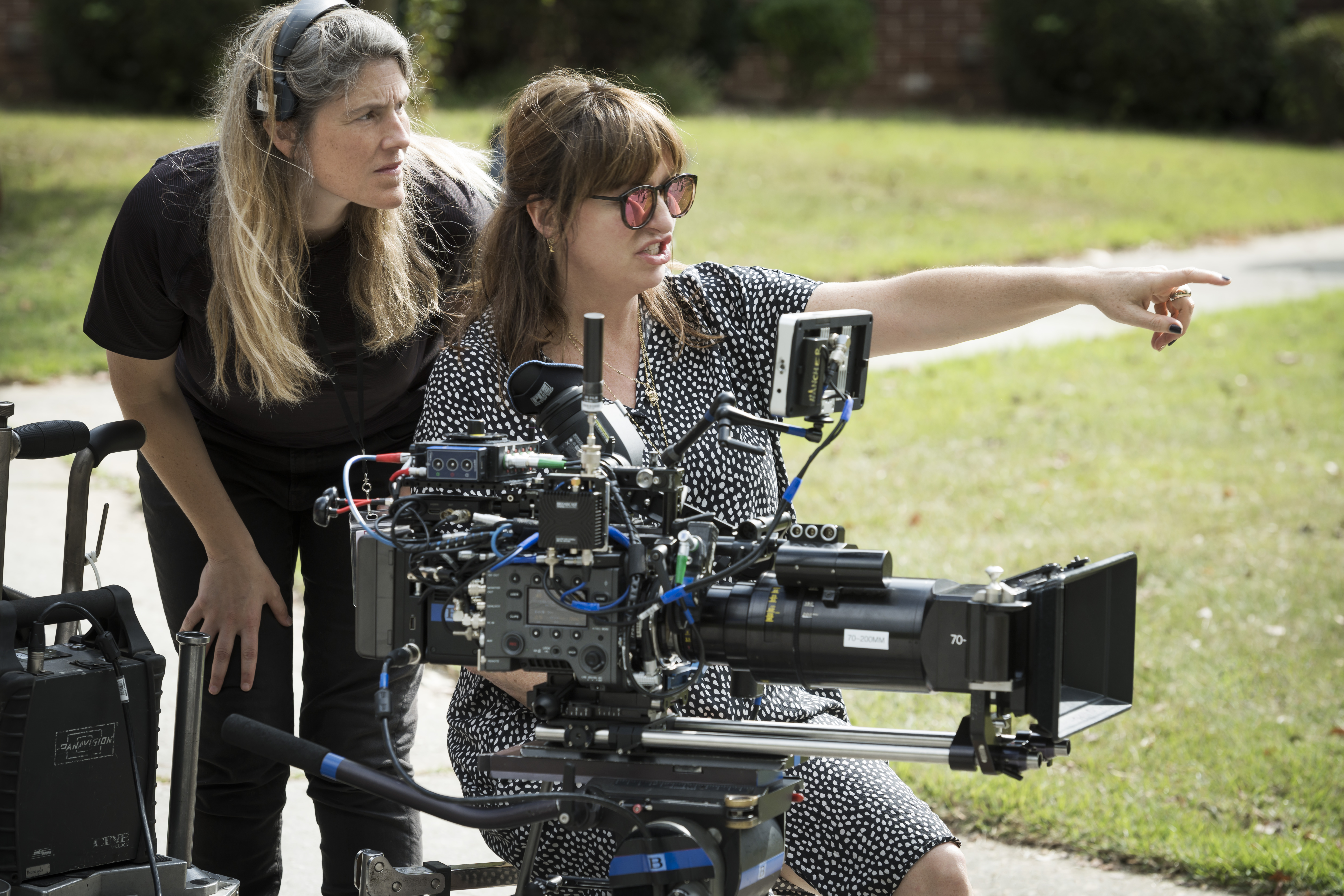 Behind-the-scenes shot of Black Widow director Cate Shortland pointing from behind a camera with a sound colleague standing behind