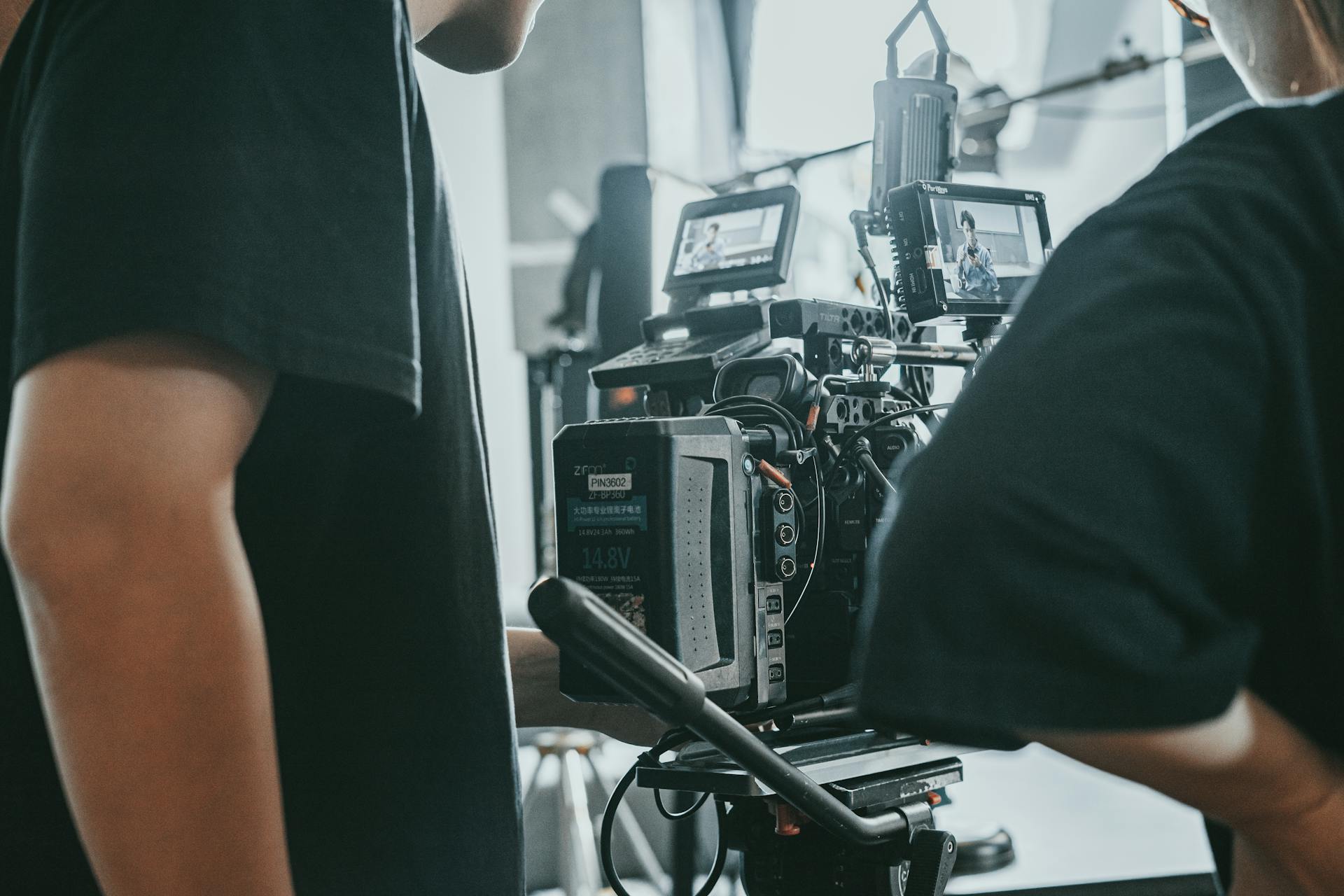 Two people stand looking at a large cinema camera