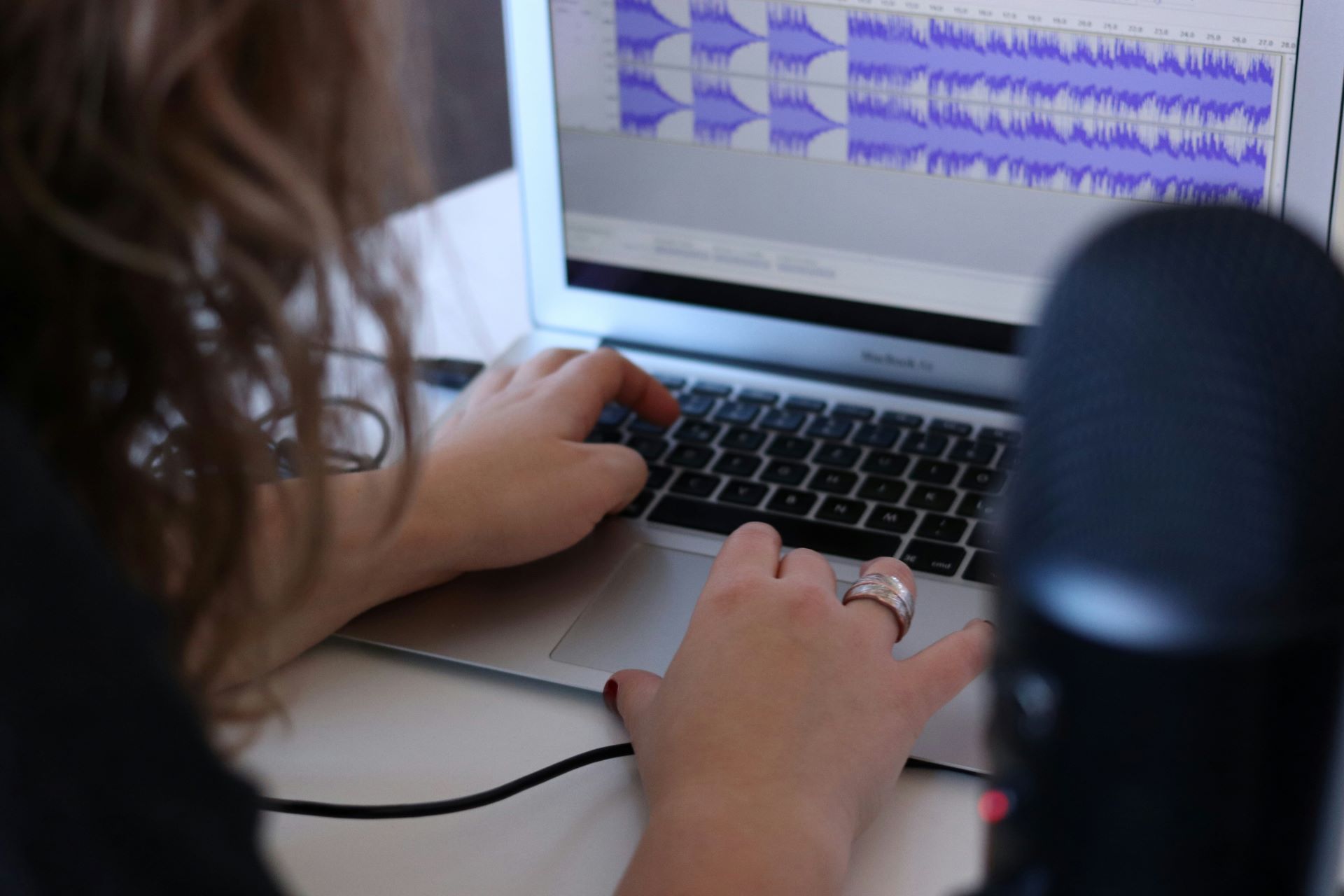 Closeup of someone editing some audio tracks in a sound editing software on a computer.