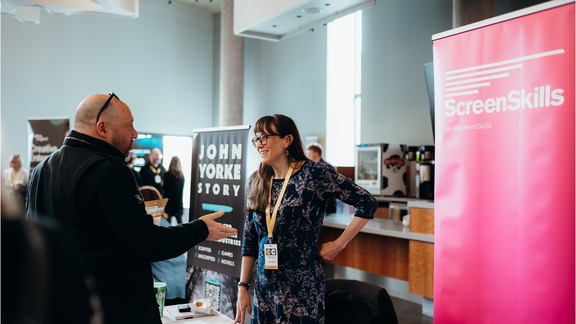 Sarah Joyce from the Unscripted TV Skills Fund talking at a stand at an event