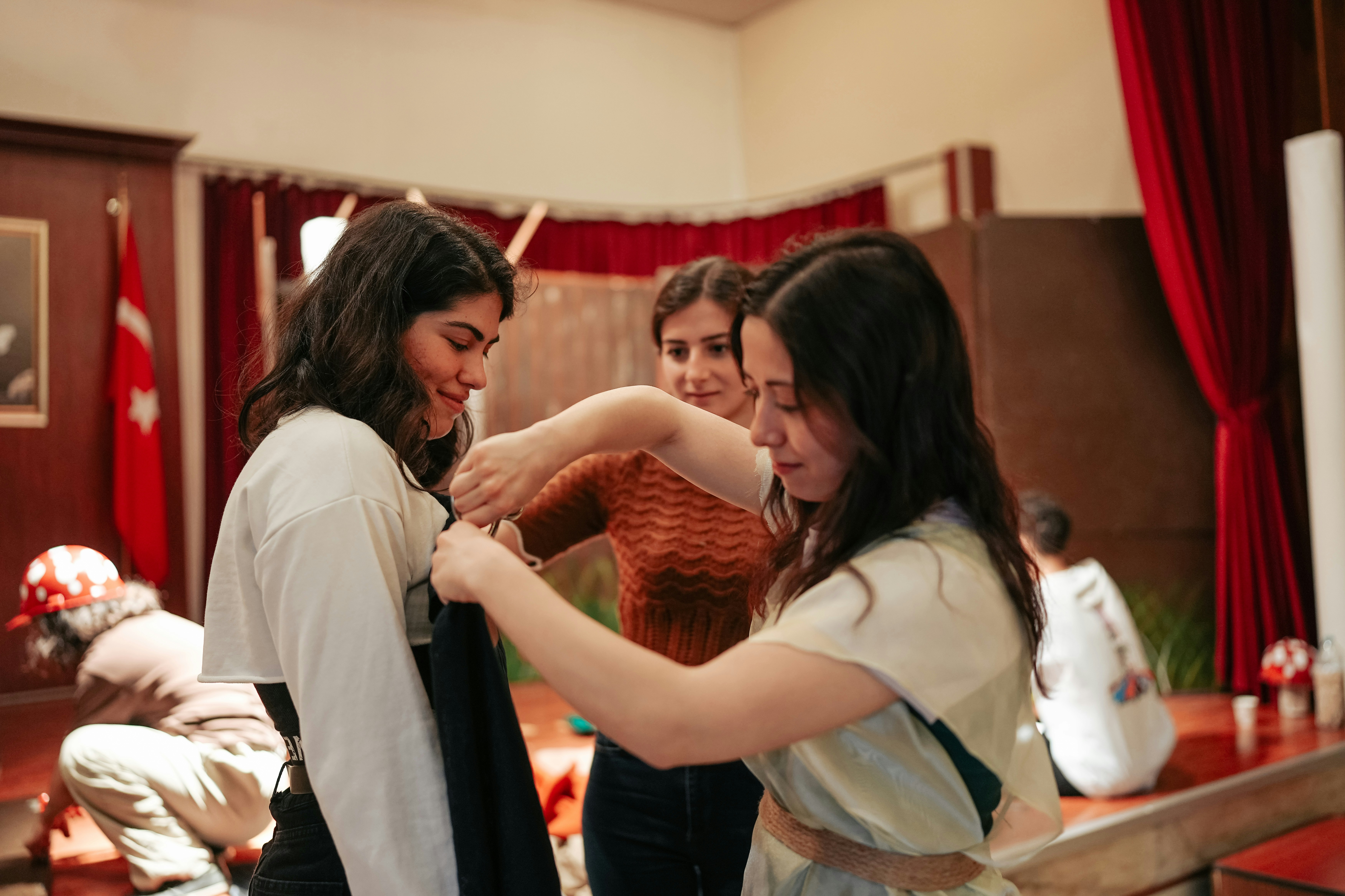 A costume designer amends the fit of an actor's outfit