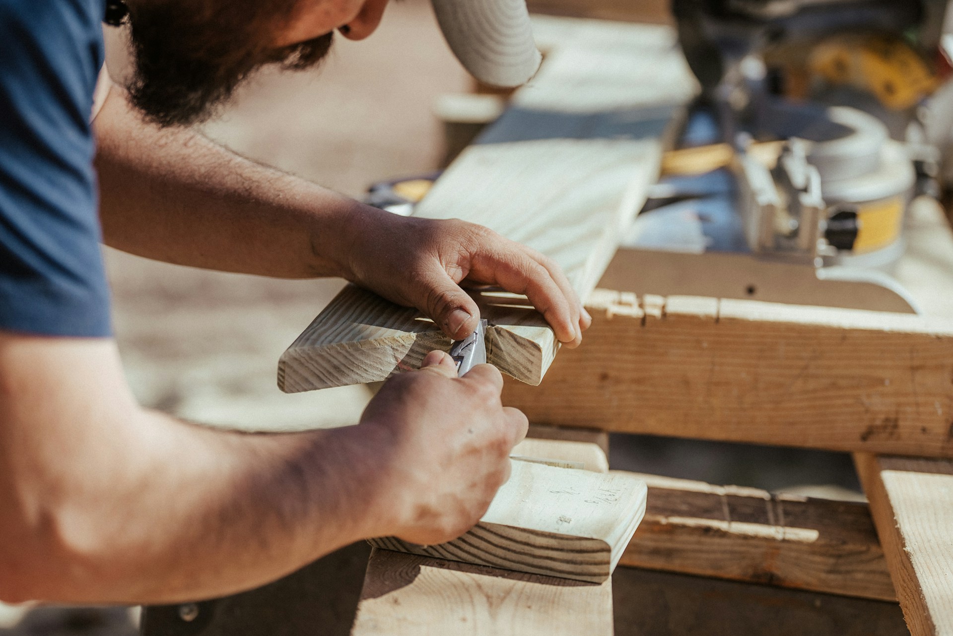 A close up of a carpenter using a tool to work with a single piece of wood