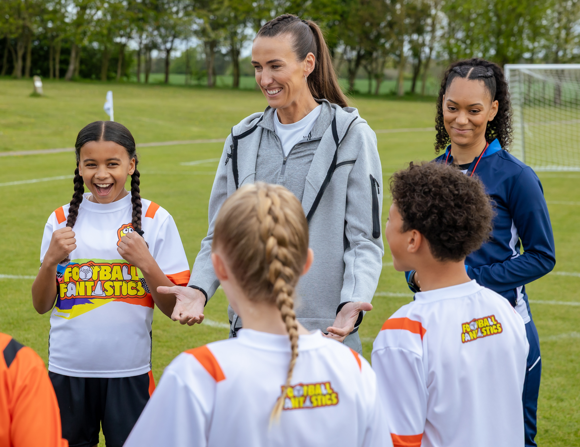 Jill Scott stands with a group of children playing football
