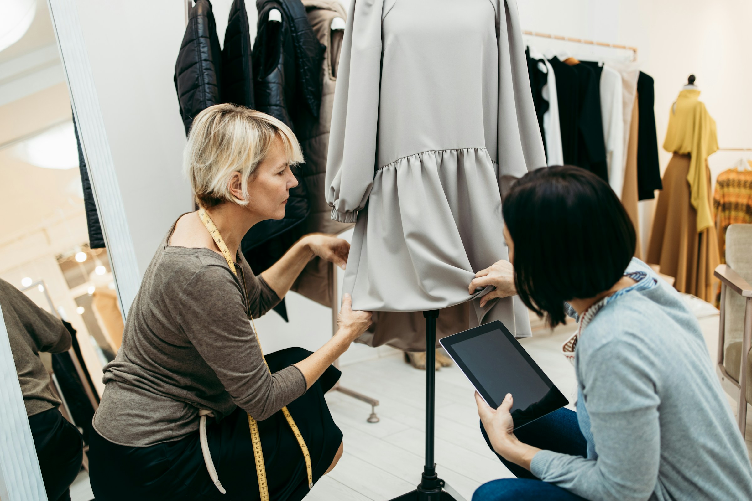 Two people looking at an item of clothing in a wardrobe